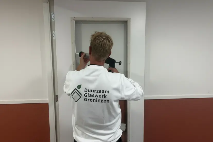 Vakman plaatst isolatieglas in woning in Groningen